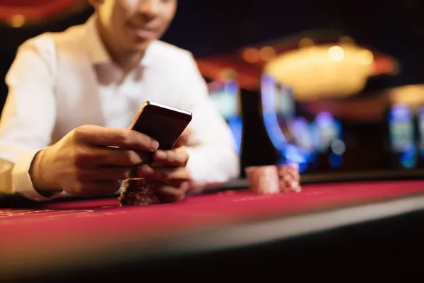 A young woman relaxing with her phone while dynamic casino elements float around her, illustrating the smooth mobile experience offered by the D63 app.